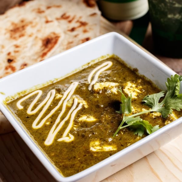 Nokturne World Kitchen's healthy green curry with paneer, cilantro, and naan bread.