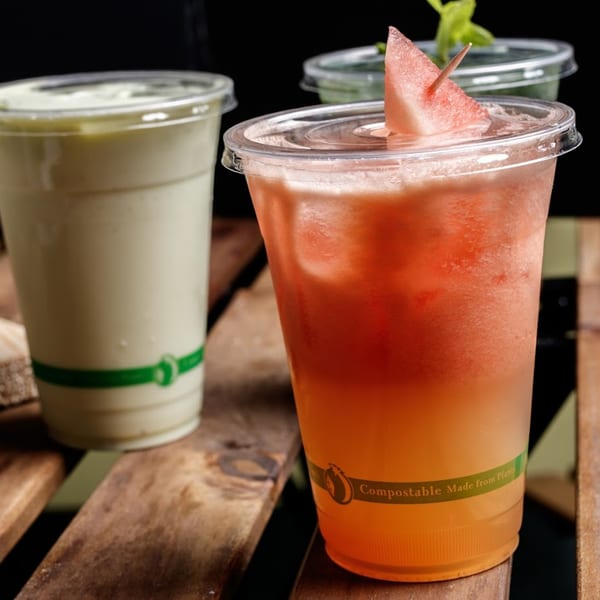 Two healthy Nokturne World Kitchen & Juice smoothies, one green and one red with a watermelon garnish.